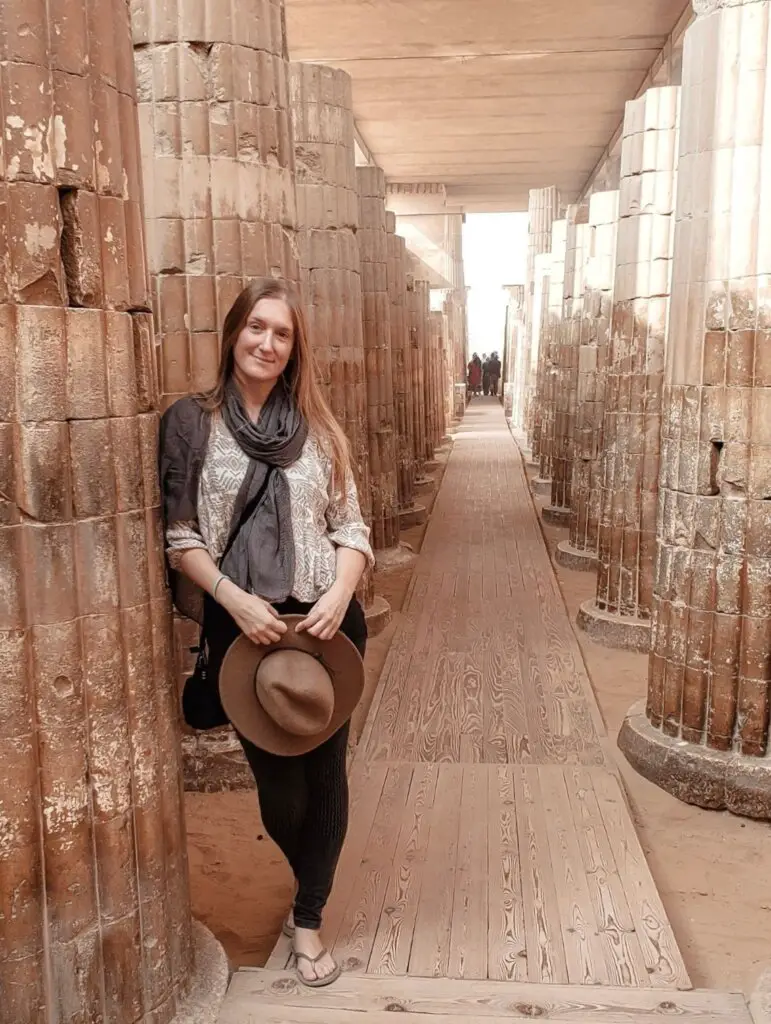 Monica leaning on a pillar,  visiting Saqqara - is Egypt expensive?