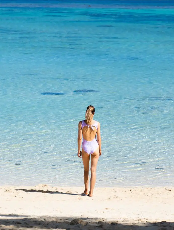 Girl walking the white sand beach on a Aitutaki day trip.
