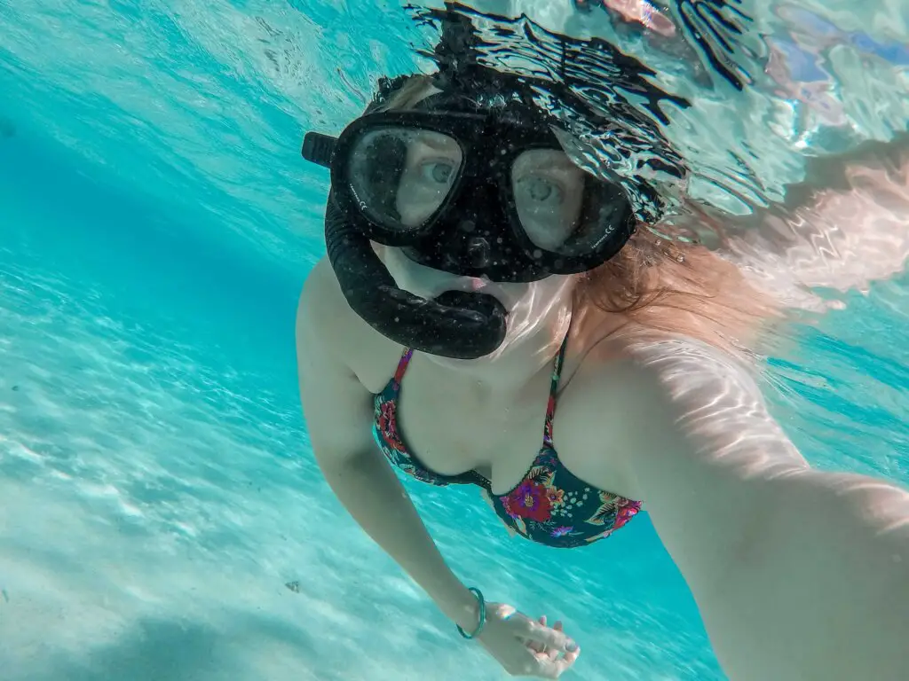 Monica swimming under the turquoise water on her Rarotonga to Aitutaki Day Trip.