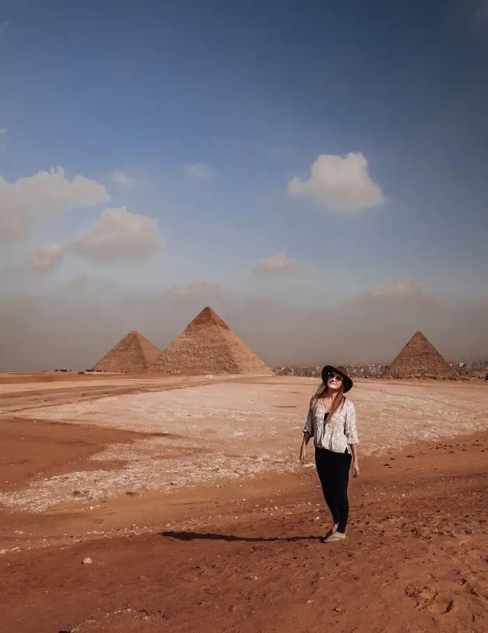 Monica standing confidently in front of the Pyramids, one of the benefits of solo travel.