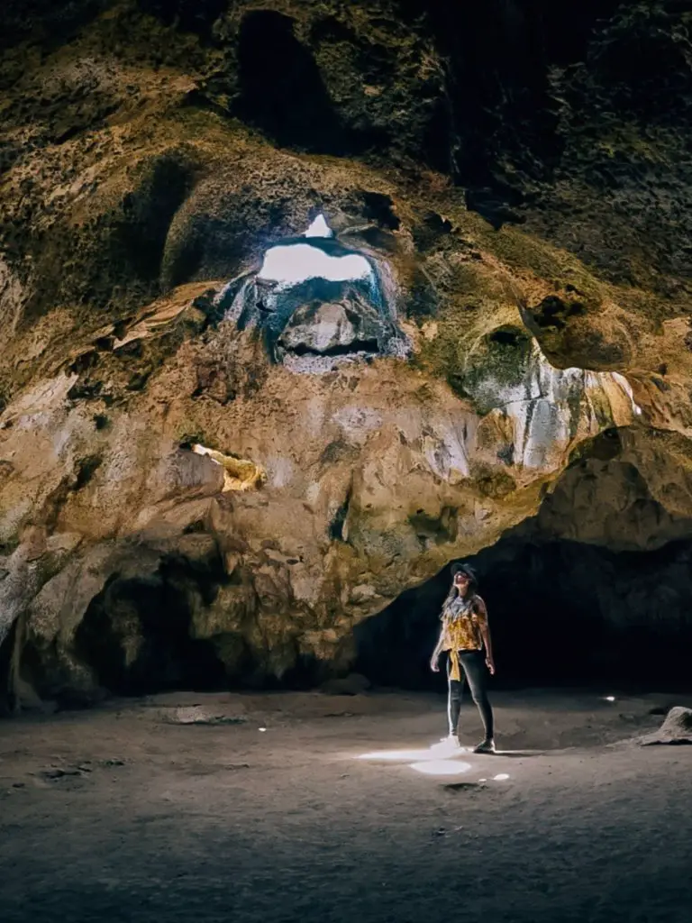 Monica adventuring inside a cave alone on a jam packed itinerary, one of the benefits of solo traveling the world.