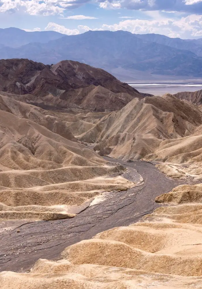 A dirt hiking trail between golden canyons at Zabriskie Point in Death Valley National Park.