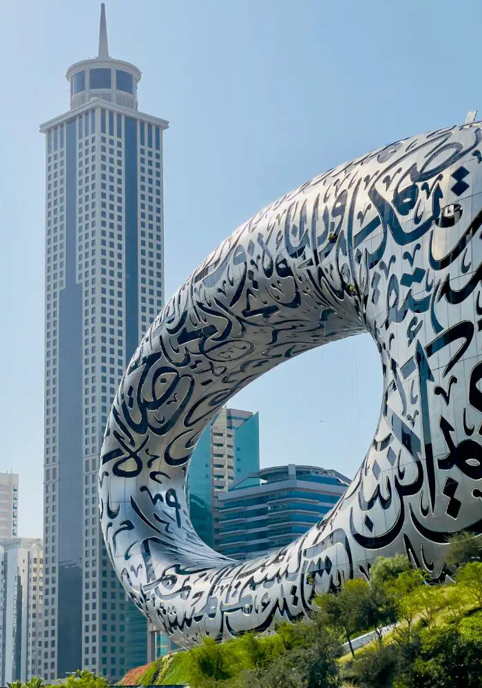 The silver oval Museum of the Future, with black Arabic script on the façade.