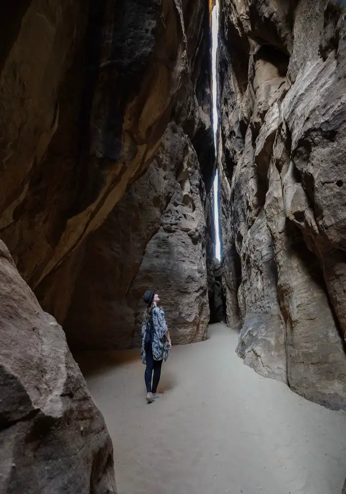 Monica wearing a loose kimono, solo traveling in Saudi Arabia as a woman, and exploring the rocks nature, and desert.