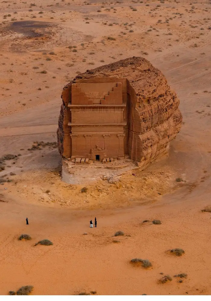 An orange stand-alone tomb at Hegra, one of the best things to do in Al ula.