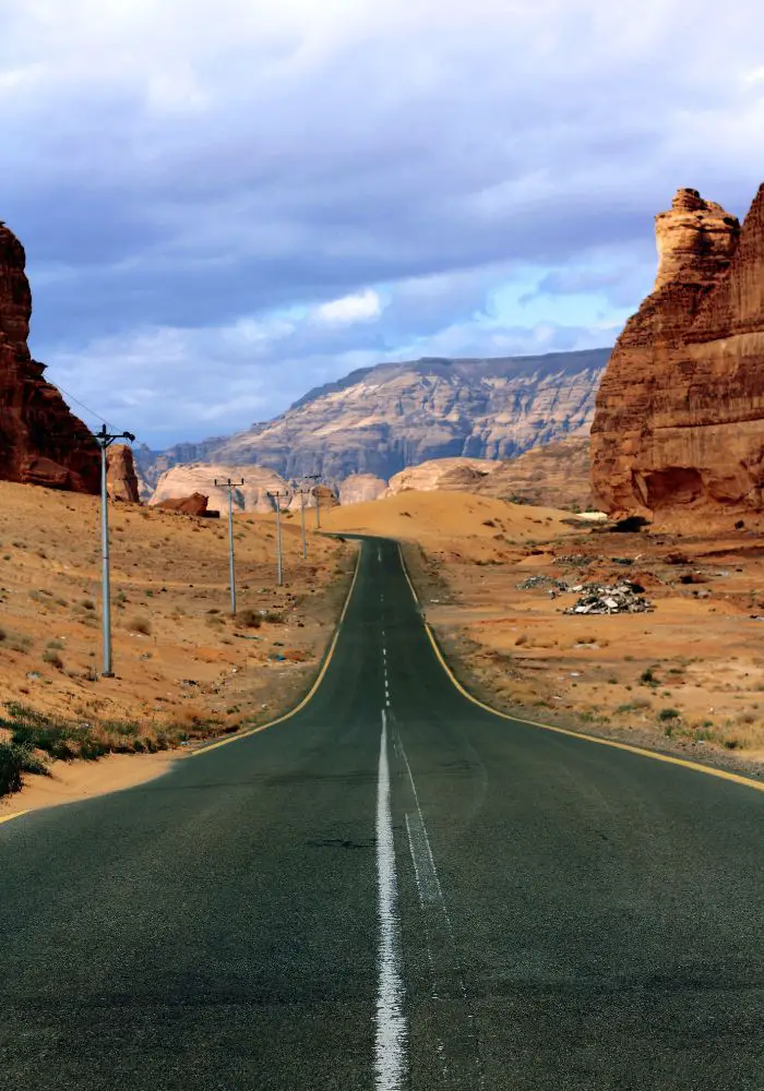 An empty paved road leading between the rocks of AlUla.