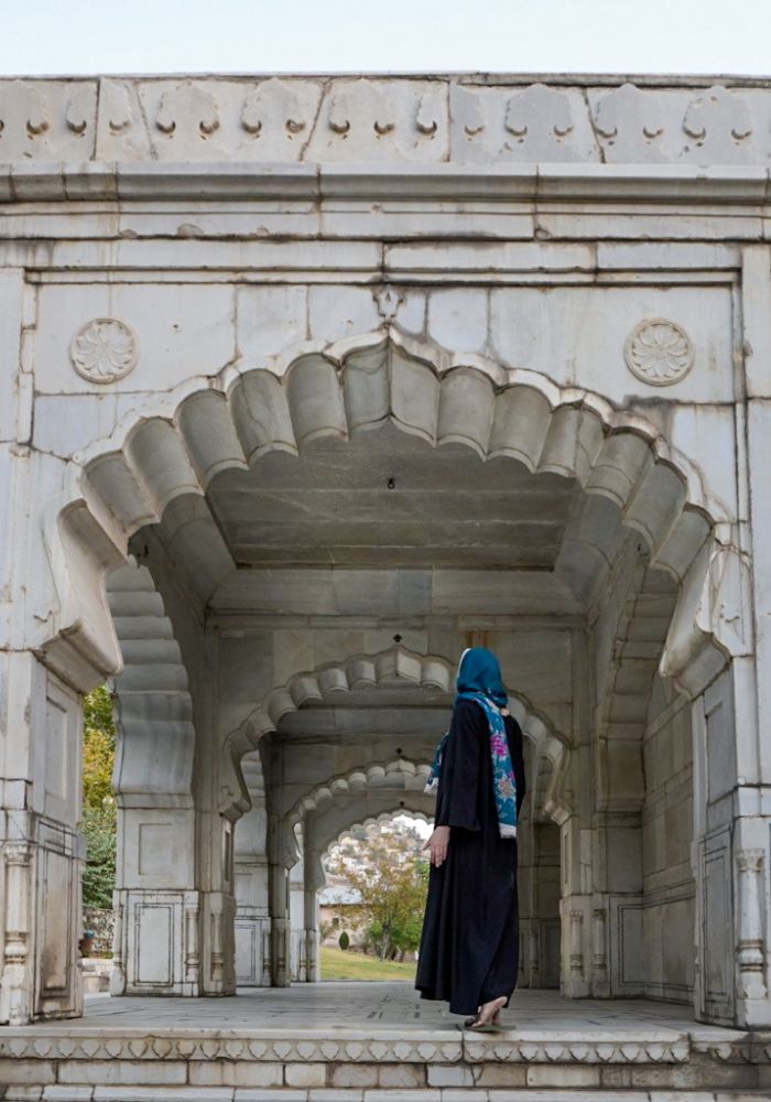 Monica wearing a black abaya and blue scarf, exploring the Babur Gardens in Kabul, one of the best places to visit in Afghanistan.