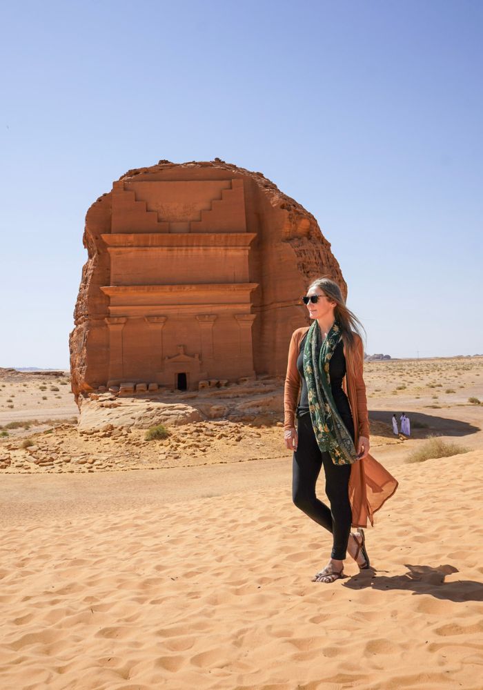 Monica in AlUla, wearing a long tan kimono, a green scarf, and head to toe black - staying conservatively covered in Saudi Arabia.