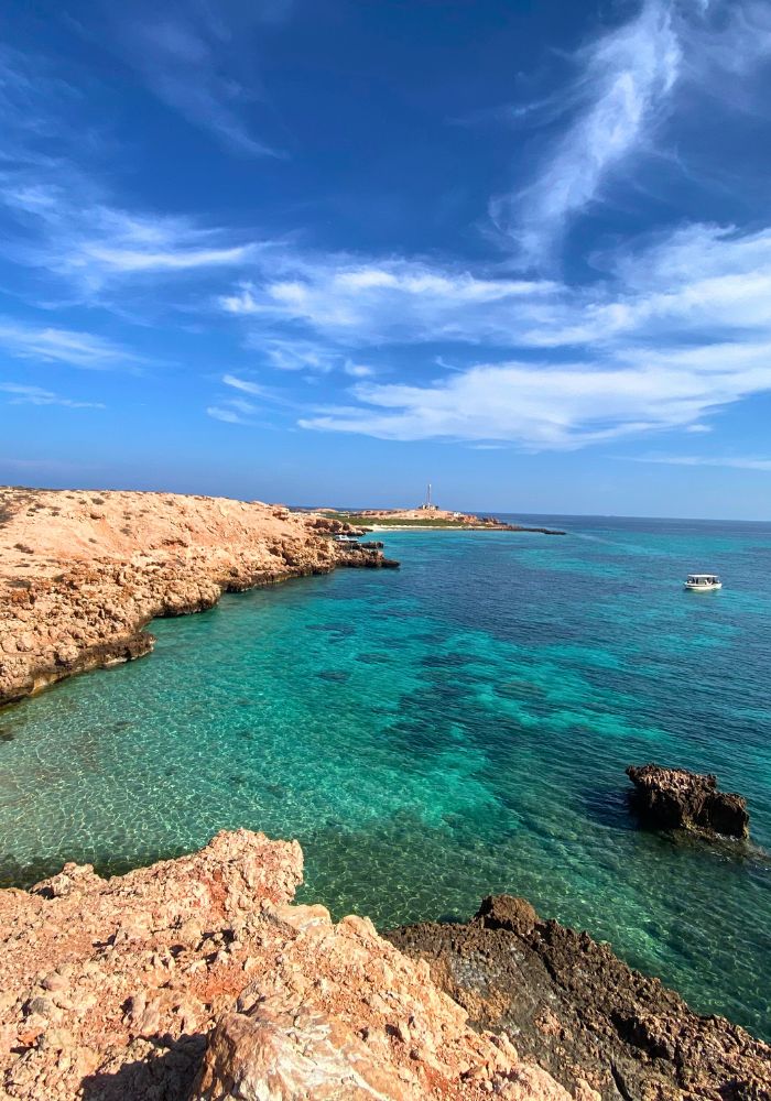 The incredible blue clear waters and rocky coast at the Dayminiyat Islands, a short day trip from Muscat.