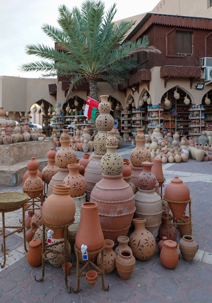 Orange and tan pottery piled up at Nizwa Souq.