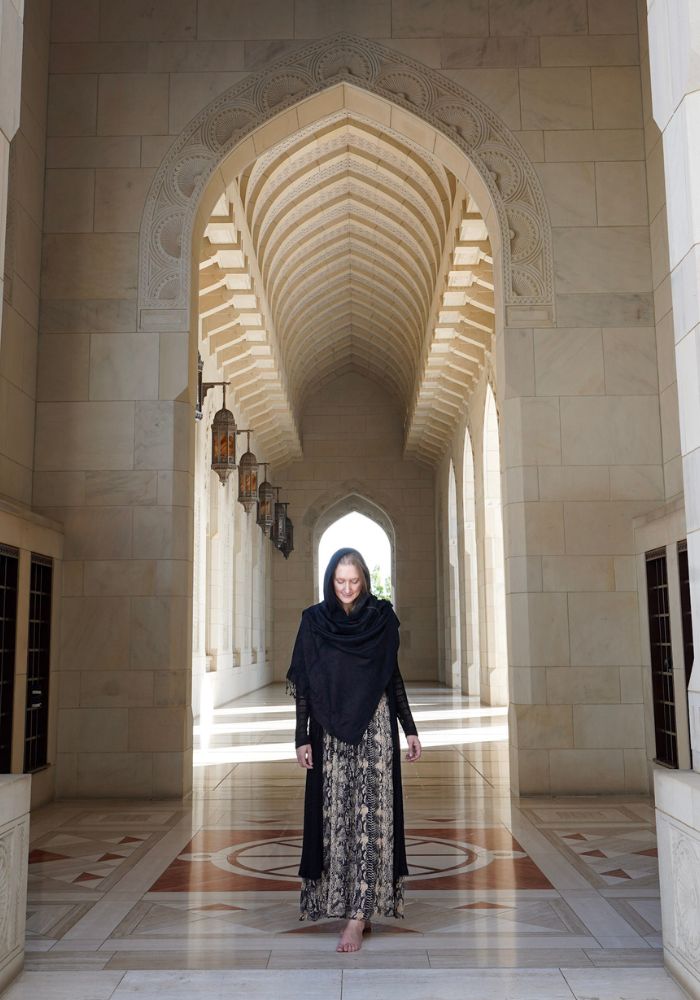 Monica feeling safe as a woman in Oman, walking in the Sultan Qaboos Grand Mosque in a long dress.