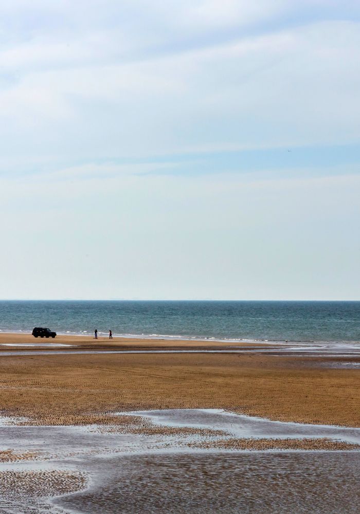 The long sandy stretches of Qurum Beach, one of the best beaches in Muscat, leading out to the blue water.