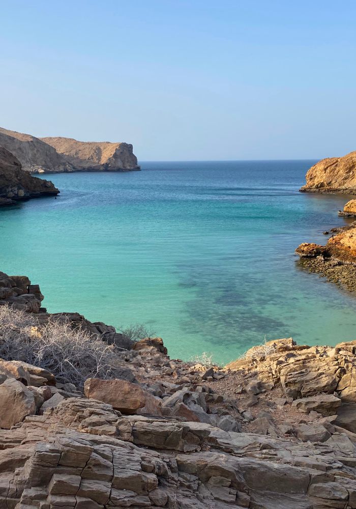 A rocky shoreline leading to Bandar Khayran's ocean, one of the best beaches in Oman.